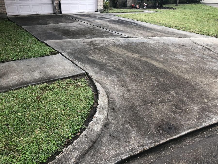 Driveway and curb stained with mildew and dirt