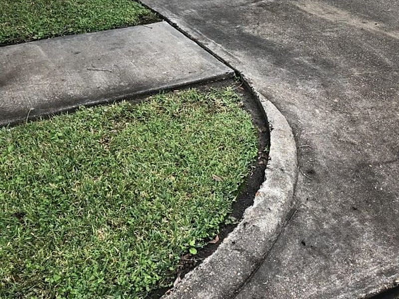 Stained sidewalk and curb before pressure washing